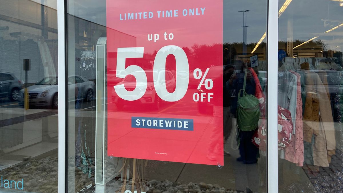A big red sign in a store window declares "up to 50% storewide" in large white type. Above it light blue letters say "for a limited time only" and below it a small banner says "storewide."